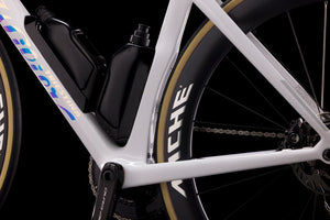 Close-up of a bicycle frame with a black battery pack and 'Shimano' branding on the wheel.